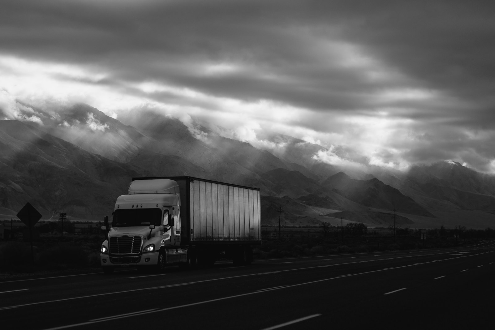 Freight truck on an open highway under a dramatic sky